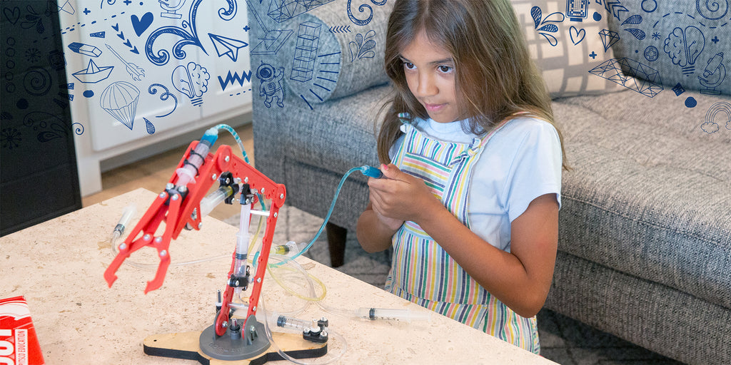 girl experimenting with her T-Bot hydraulic robot arm