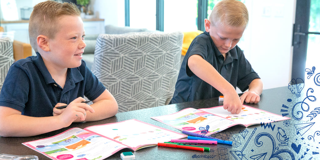 Twin boys stamping their fingerprints in their Pioneering Fingerprints activity guide