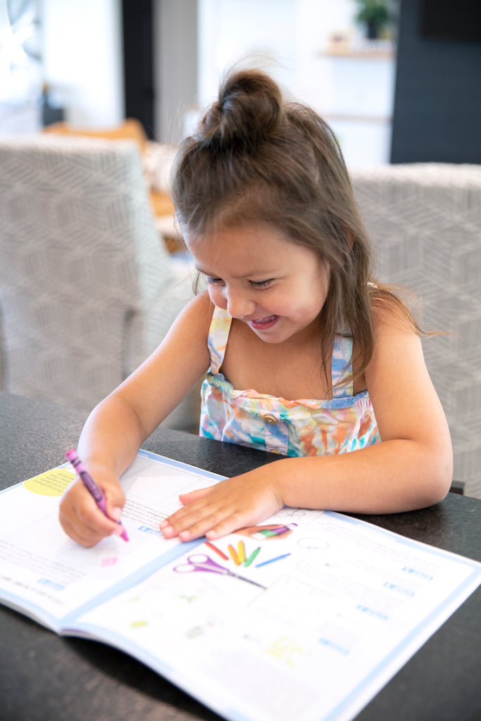 Girl coloring in her STEAMbright activity book