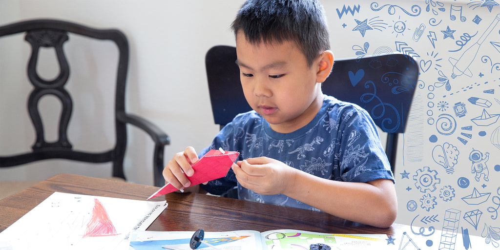 boy adding wheels to his vehicle with the Exploring Vehicles Kit