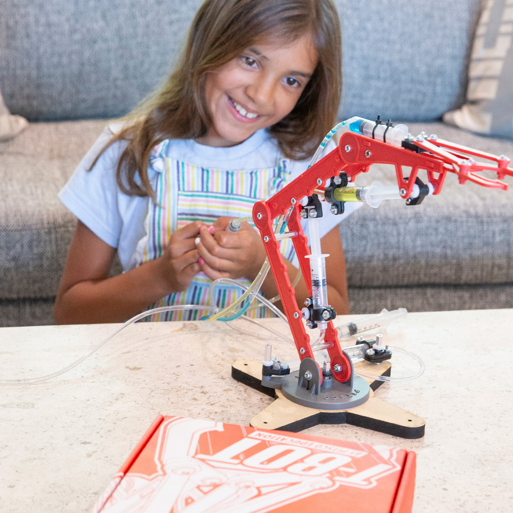 Middle-school aged girl puts together T-Bot hydraulic arm