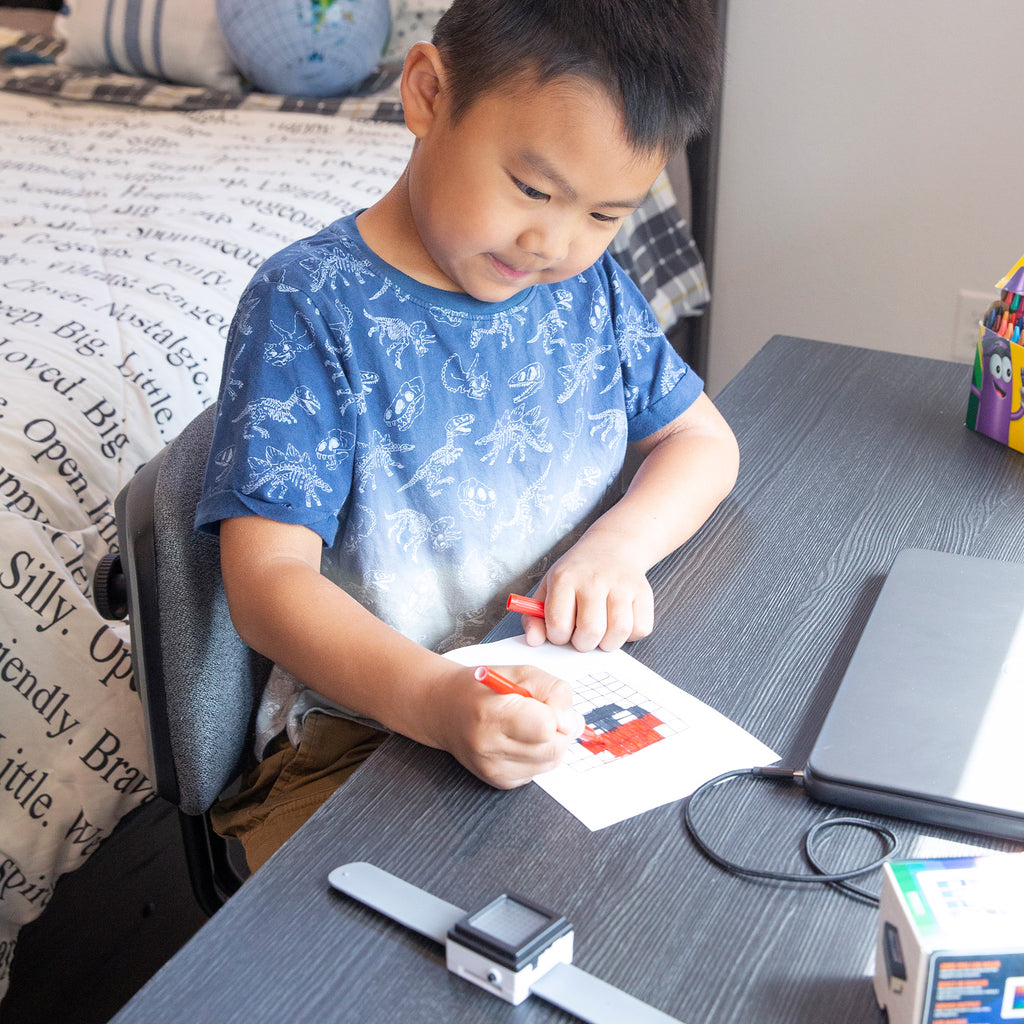 Young boy coloring and learning coding with Code Cube