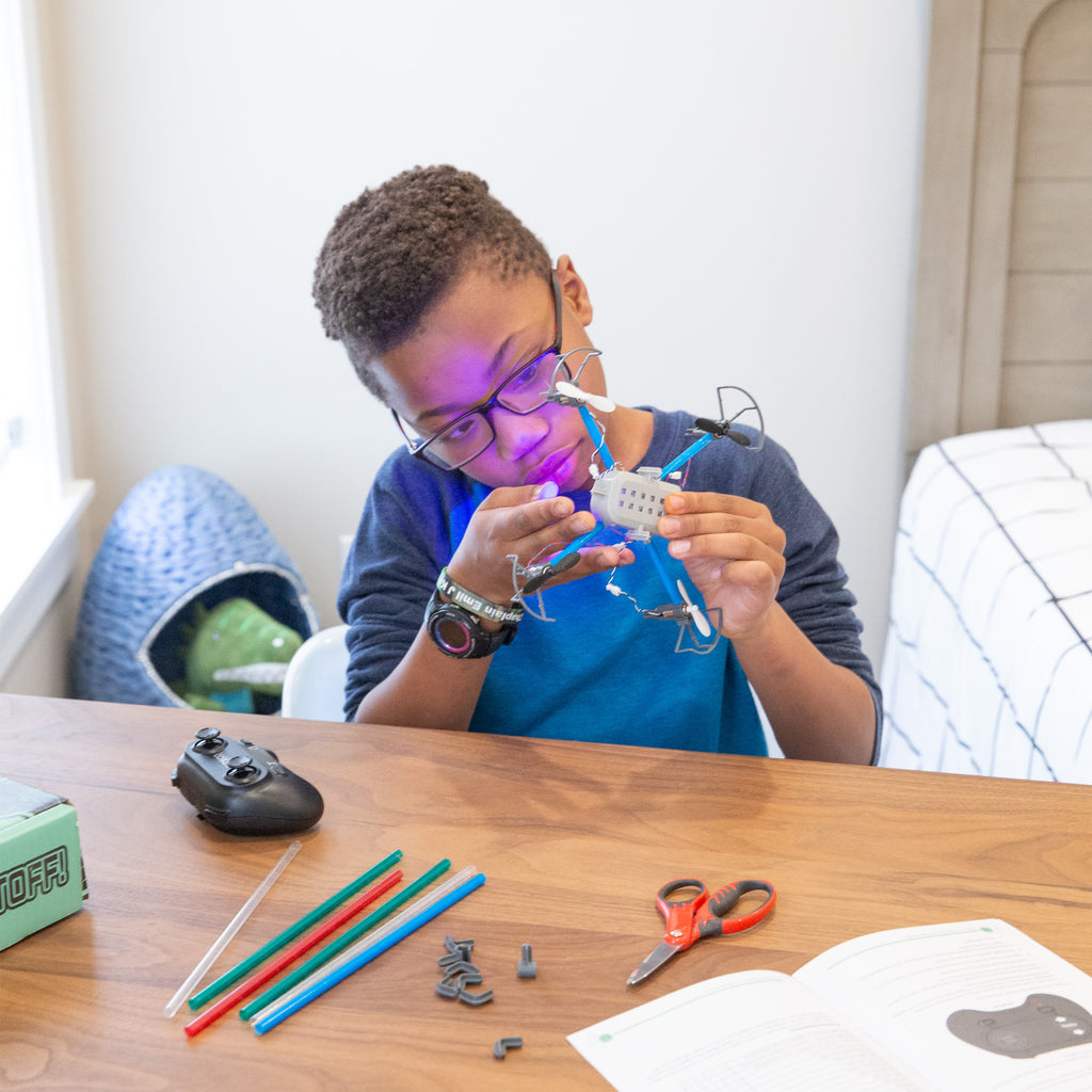Middle-school aged child plays with drone maker kit at home