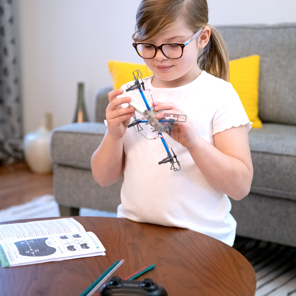 Little girl plays with drone maker kit
